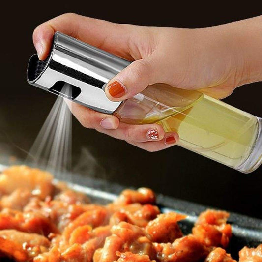 Oil sprayer bottle spraying olive oil onto cooked shrimp